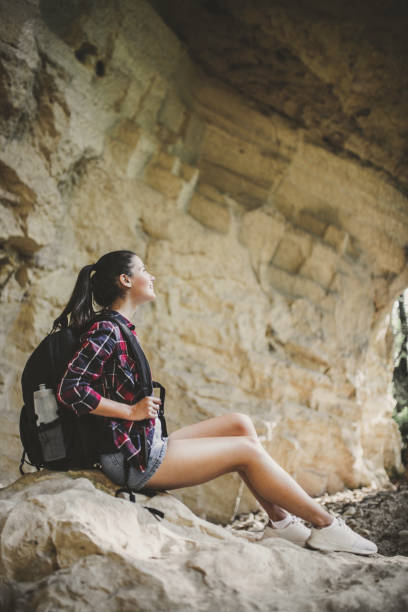 istock Woman sitting on mountain rocks 1170347198