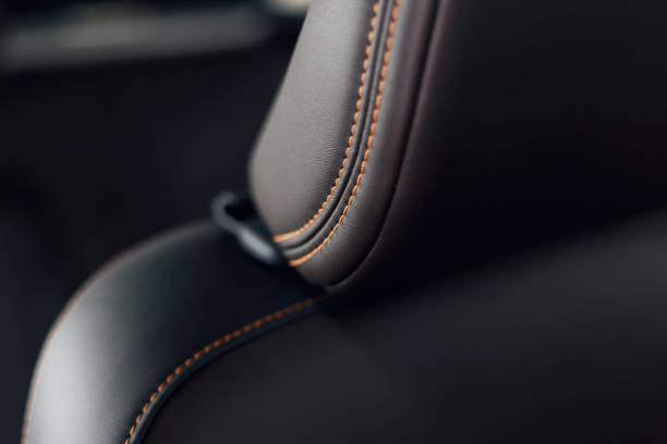 parte do interior de couro costurado de couro preto do carro. interior de couro perfurado preto do carro luxuoso moderno. detalhes interiores de couro do carro - belt leather fashion personal accessory - fotografias e filmes do acervo