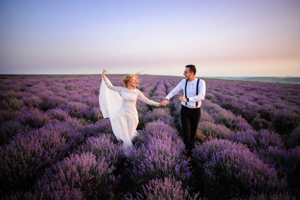 istock Happy newlyweds running along blooming lavender field 1170348161