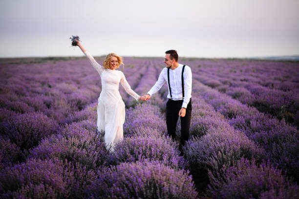 istock Happy newlyweds running along blooming lavender field 1170348168