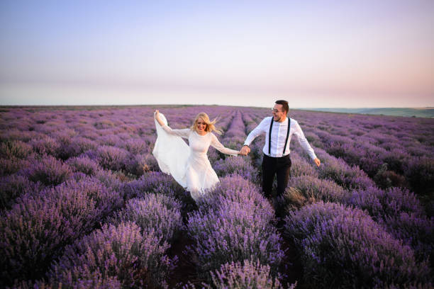 istock Happy newlyweds running along blooming lavender field 1170348190