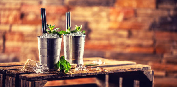 Mint julep cocktail alcoholic drink on wooden board in pub or restaurant Mint julep cocktail alcoholic drink on wooden board in pub or restaurant. mint julep photos stock pictures, royalty-free photos & images