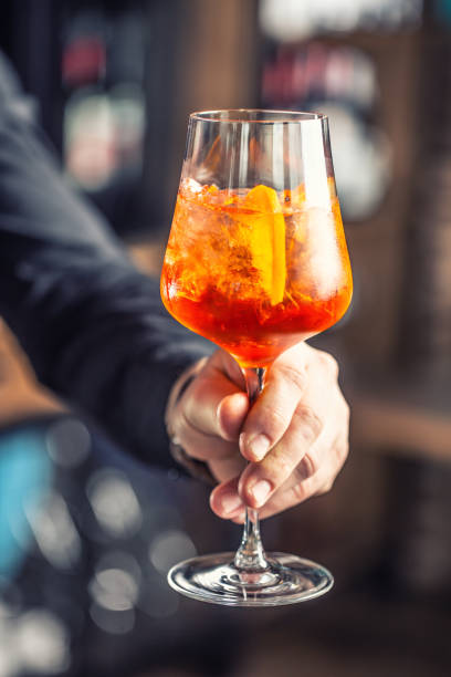 istock Spritz drink. Bartender hand holding glass with  Spritz drink 1170348572