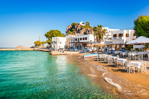 Bright and colorful horizontal image of Skala town. Clear blue sky and small  beach close to the harbor of Patmos, Greece.