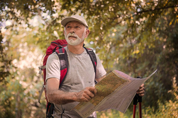 Senior man hiking in the mountains with backpack.
