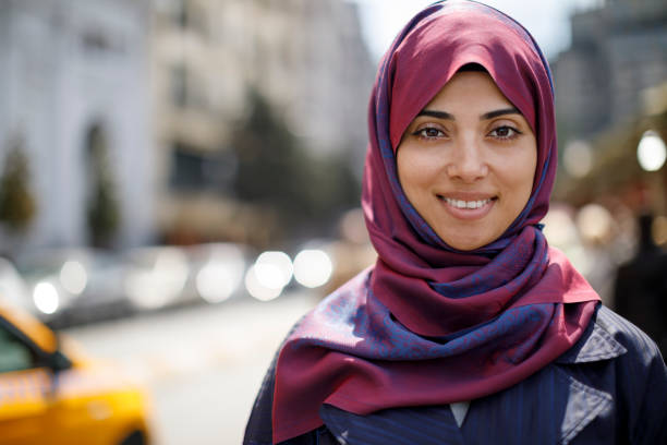 Portrait of smiling muslim woman in the city Portrait of smiling muslim woman in the city arabic girl stock pictures, royalty-free photos & images