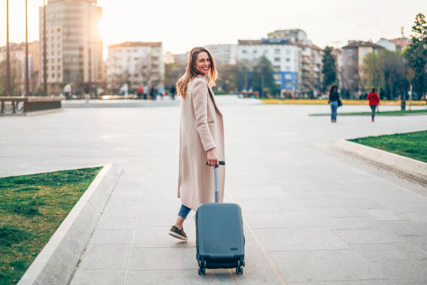 istock Fashionable woman pulling suitcase 1170359540