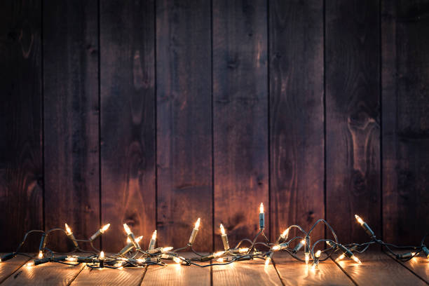 istock Empty rustic wooden table with Christmas lights at the bottom border 1170359649