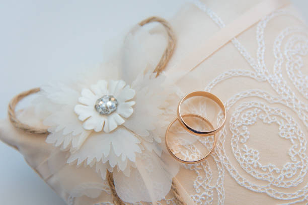 istock Two golden wedding rings on a lace pad 1170360655