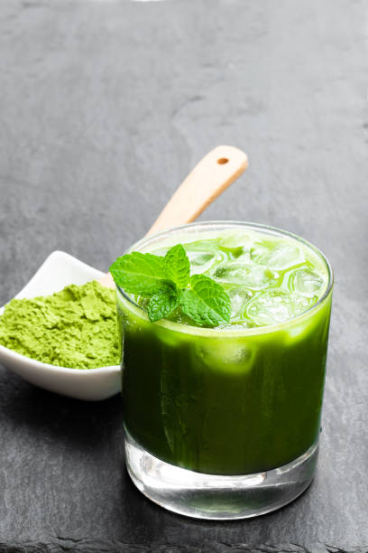 istock Homemade iced matcha latte tea on black stone background 1170361900