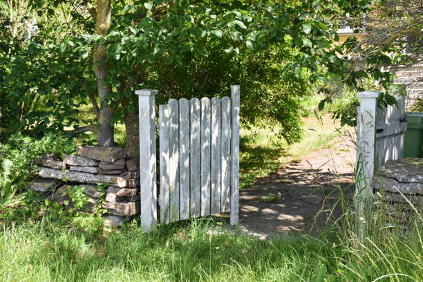 Open white gate into a garden stock photo