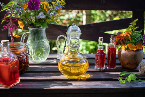 botellas de borage y aceite de hierba de san juan, con hierbas medicinales frescas y flores - mortar and pestle wood healthcare and medicine jar fotografías e imágenes de stock