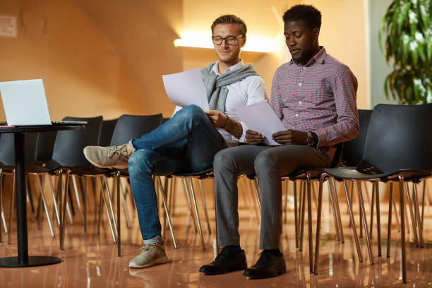 istock Concentrated young multi-ethnic men focused on papers reading presentation text in conference room 1170370776