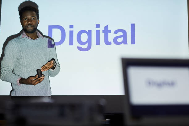 istock Content confident young Black man in sweater standing by projection screen and presenting digital project to investors 1170371162