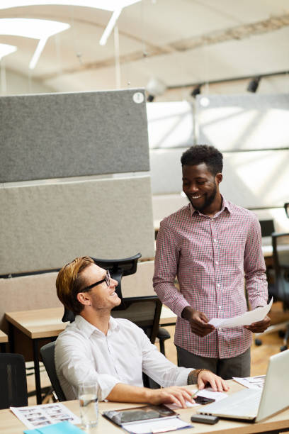 istock Cheerful creative young multi-ethnic men working in team and choosing design for digital project 1170371877