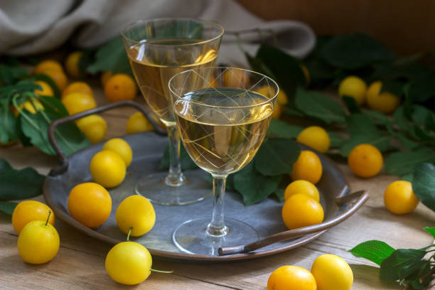 cherry plum liqueur in small glasses and cherry plum on a wooden background. rustic style. - plum fruit organic food and drink imagens e fotografias de stock