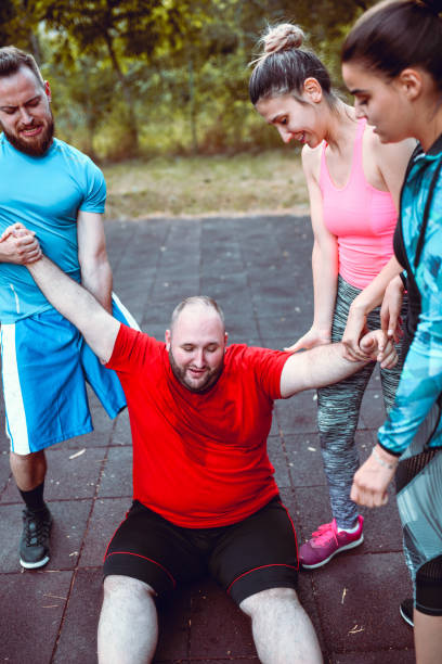 istock Friends Pulling Up Overweight Male After Hard Training 1170375561