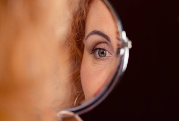istock woman eye reflected in a round small mirror. 1170376321