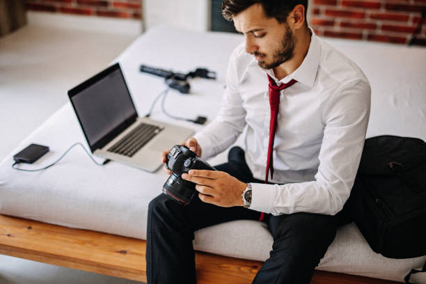 istock A man at a hotel is changing the batteries on his camera 1170379381