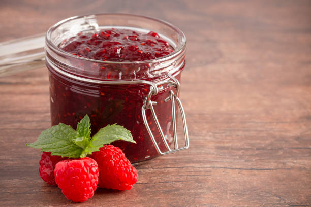istock A Jar of Raspberry Jam on a Rustic Wooden Table 1170382747