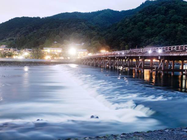 ponte de togetsu-kyo e rio de katsura no crepúsculo, arashiyama, kyoto, japão. - togetsu kyo bridge - fotografias e filmes do acervo