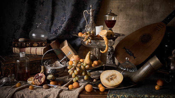 Still life with fruits A classic still-life in the Dutch old masters painting style with  fruits on a silver, platter, silver carafe. old books , glass of wine, hunting horn and guitar lute . still life stock pictures, royalty-free photos & images