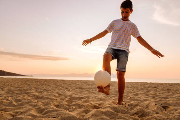 istock Boy playing soccer on the beach 1170384893