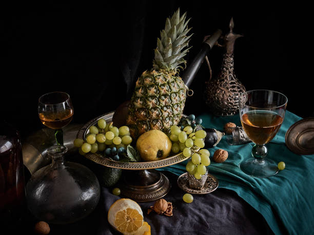 Still life with pineapple A classic still-life in the Dutch old masters painting style with pineapple, fruits on a silver, platter, silver carafe with dragon ornament, glass of wine, dutch baroque architecture stock pictures, royalty-free photos & images