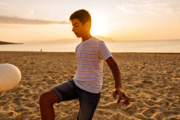 istock Boy playing soccer on the beach 1170385076