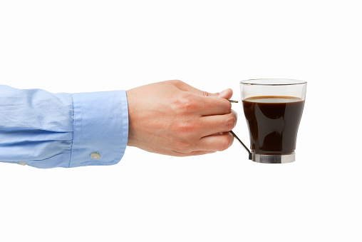 Close up of a businessman hand holding a cup in a coffee with white background