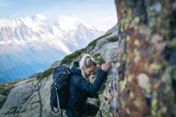 jeune femme randonnées à travers des rochers alpins - success determination idyllic carefree photos et images de collection