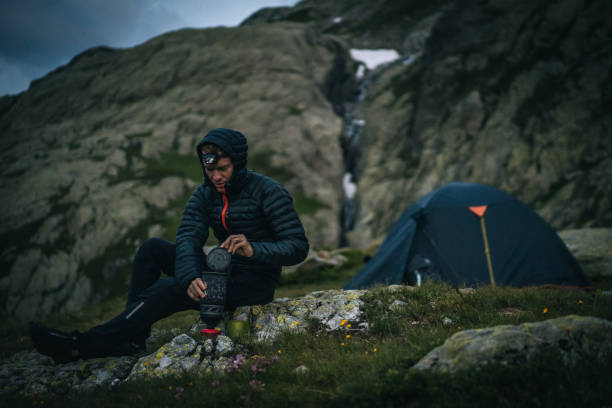 istock Hiker prepares hot beverage with headlamp in alpine campsite 1170399373