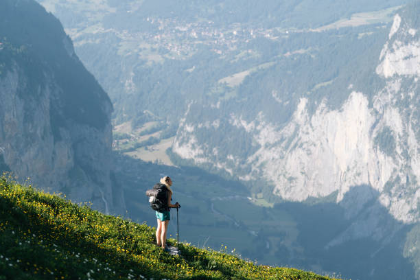 istock Young woman hikes through alpine above valley 1170399466