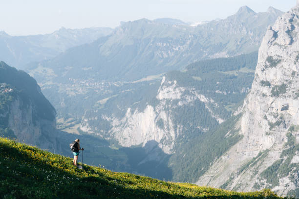 istock Young woman hikes through alpine above valley 1170399595