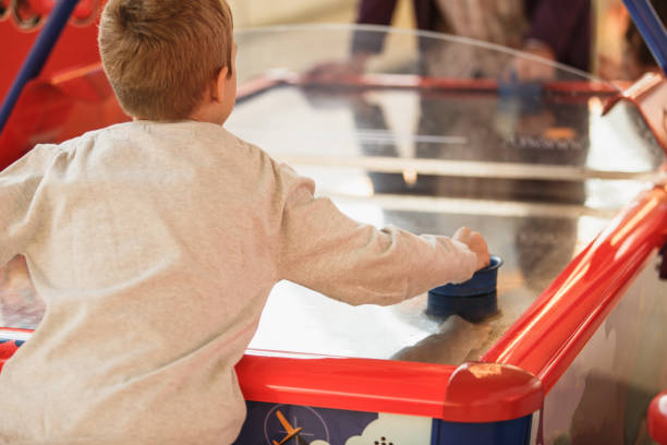 istock Boy playing air hockey in game room 1170400144