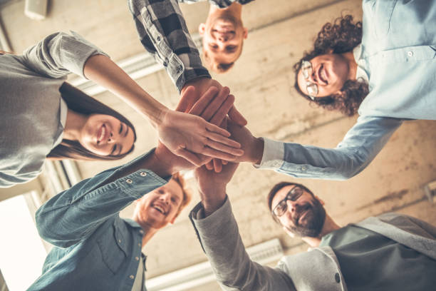 istock Startupers working at office together standing holding hands bottom view close-up laughing joyful support 1170400301