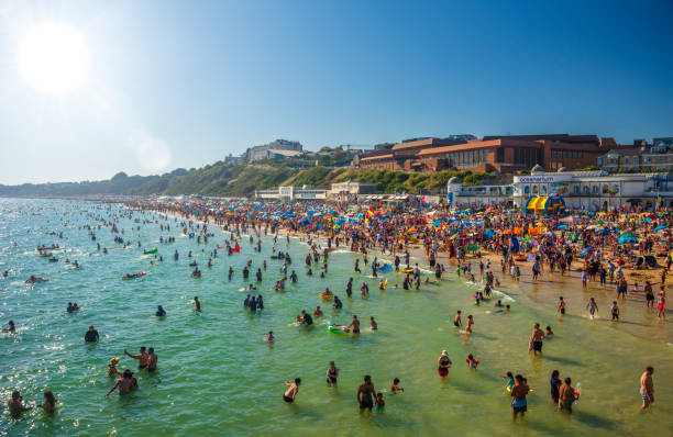 Thousands of sun seekers pack the beach, Bournemouth, Dorset Record temperatures cause thousands of sun seekers to flock to beaches all along the coast between Poole and Bournemouth, Dorset boscombe photos stock pictures, royalty-free photos & images