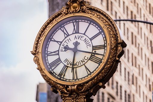 5TH Avenue clock with the Flatiron Building in the background