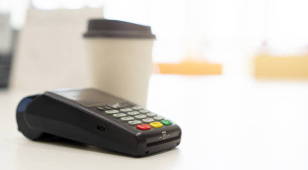 istock close up an electronic banking money machine with hot beverage cup on white table counter in coffee bar shop with copy space background for business and  technology of contactless payment concept 1170405743