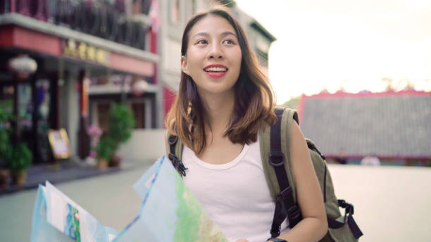 istock Cheerful beautiful young Asian backpacker woman direction and looking on location map while traveling at Chinatown in Beijing, China. Lifestyle backpack tourist travel holiday concept. 1170406762