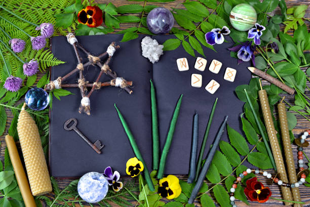 istock Magical objects with pentagram, open book, healing crystals, runes and candles on witch table. 1170407797