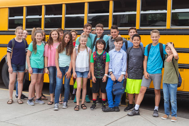 istock Portrait of elementary students next to a school bus 1170409707