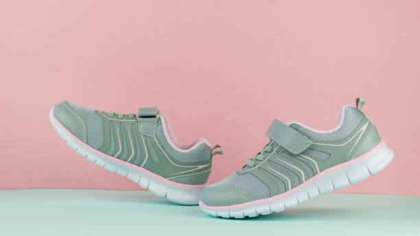 istock Women's sneakers pink and gray walking on a blue background. 1170413184