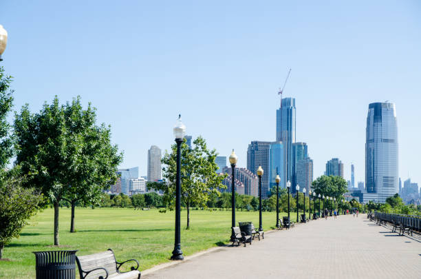 Series of benches in Liberty State Park during summer day with Manhattan behind