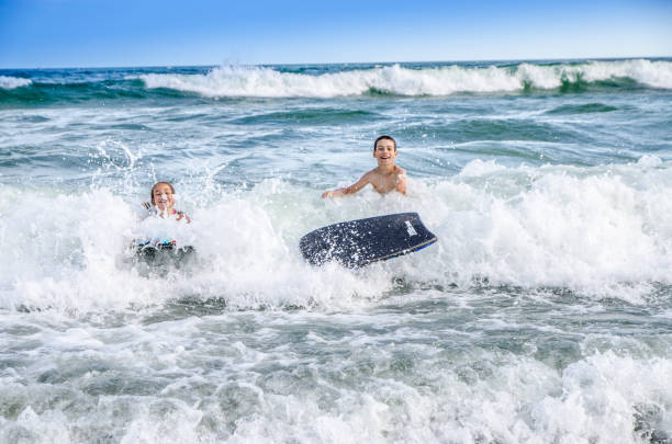 istock Young kids with small surfboard at the beach 1170419598
