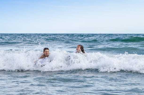 istock Young kids with small surfboard at the beach 1170419600