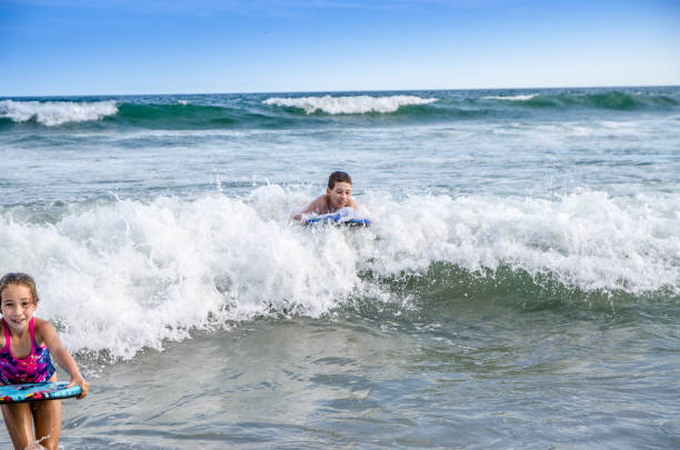 istock Young kids with small surfboard at the beach 1170419709
