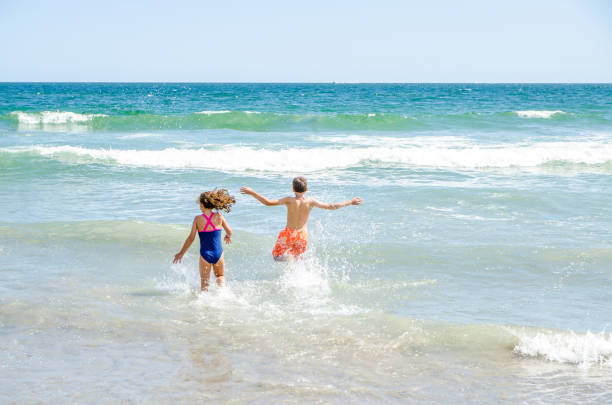 istock Kids running into water at the beach 1170419755