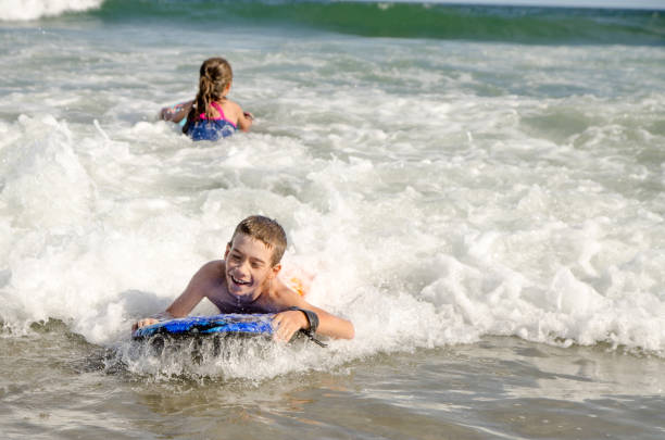 istock Young kids with small surfboard at the beach 1170419767