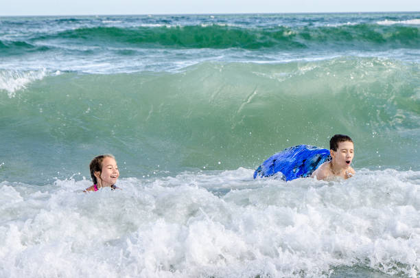 istock Young kids with small surfboard at the beach 1170419777